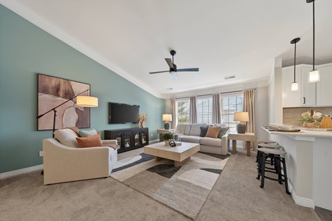 A living room with a couch, a chair, a coffee table, and a painting on the wall.