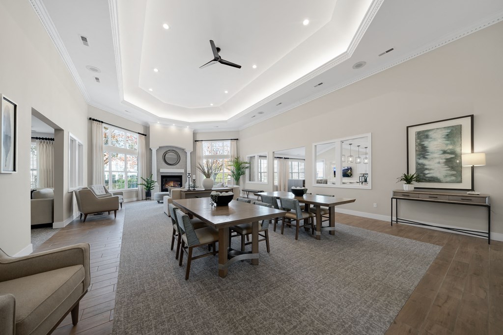 a large living room with a large table and chairs at Cidermill Village Apartments in Rochester Hills, MI 