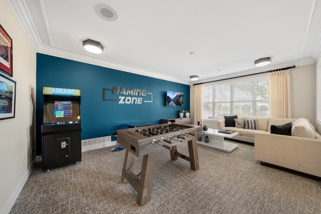 a game room with a foosball table and a video game at Cidermill Village Apartments in Rochester Hills, MI 