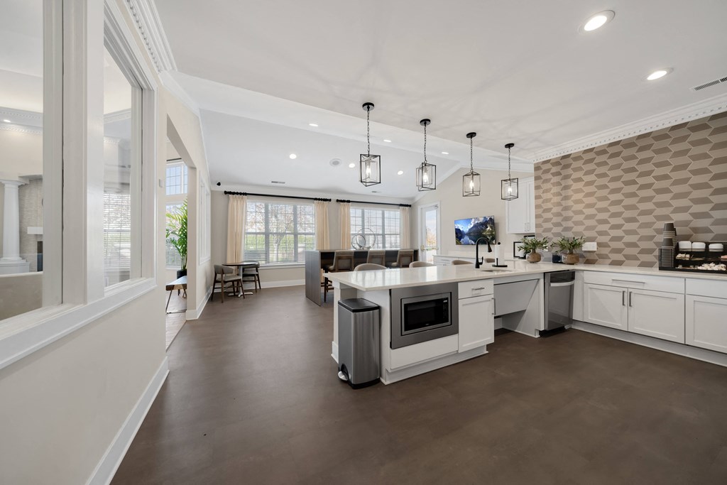 a large kitchen with white cabinets and a white counter top at Cidermill Village Apartments in Rochester Hills, MI 