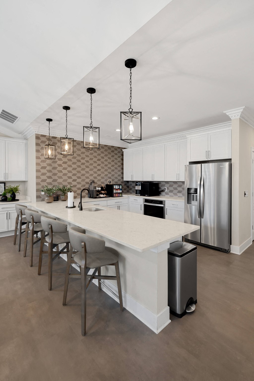 a large white kitchen with a large island and stainless steel appliances at Cidermill Village Apartments in Rochester Hills, MI 