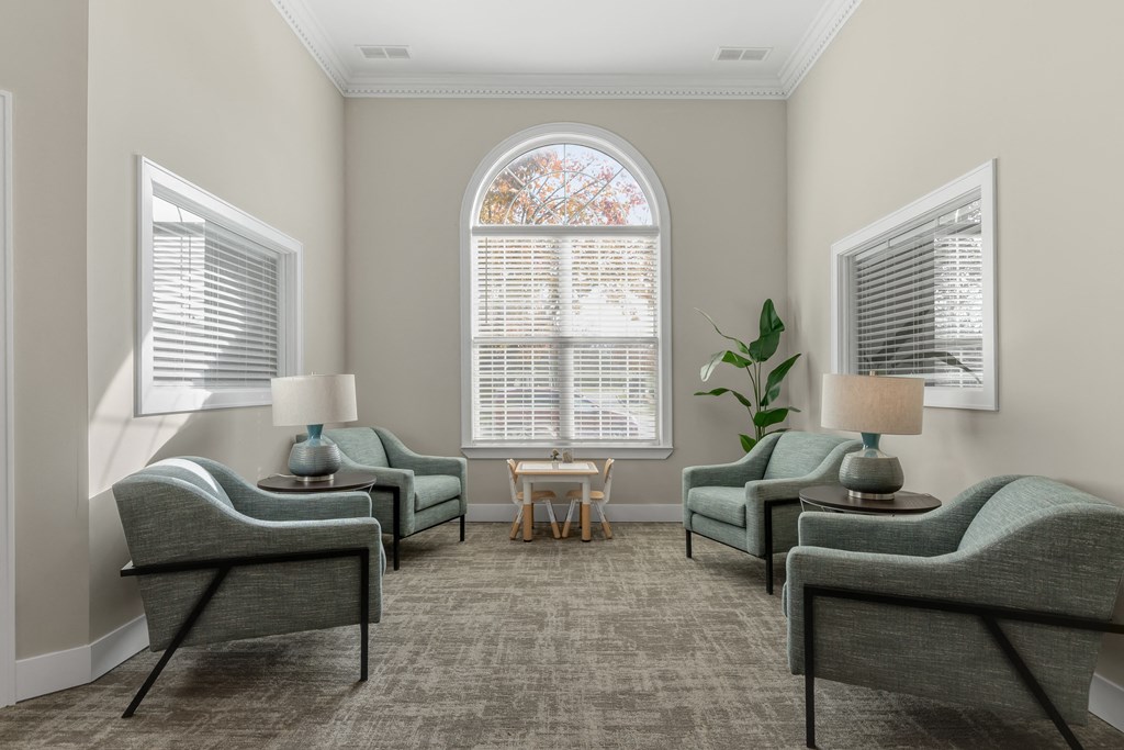 a living room with couches and chairs and a window at Cidermill Village Apartments in Rochester Hills, MI 