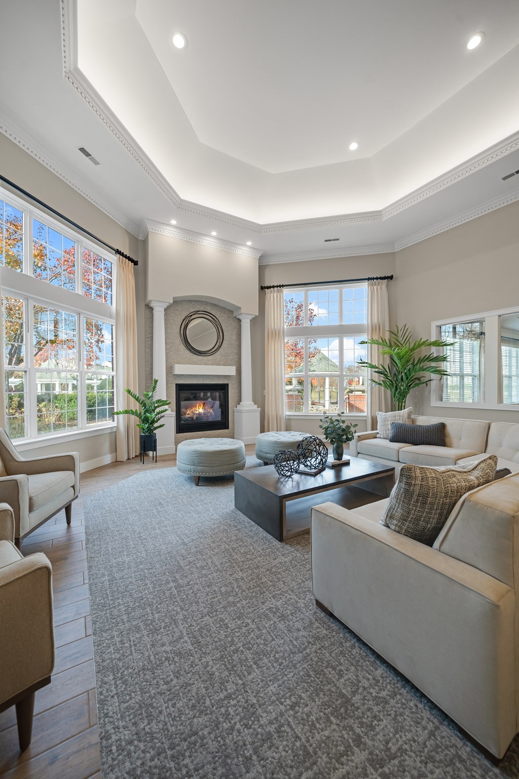 a living room with couches and chairs and a fireplace at Cidermill Village Apartments in Rochester Hills, MI 