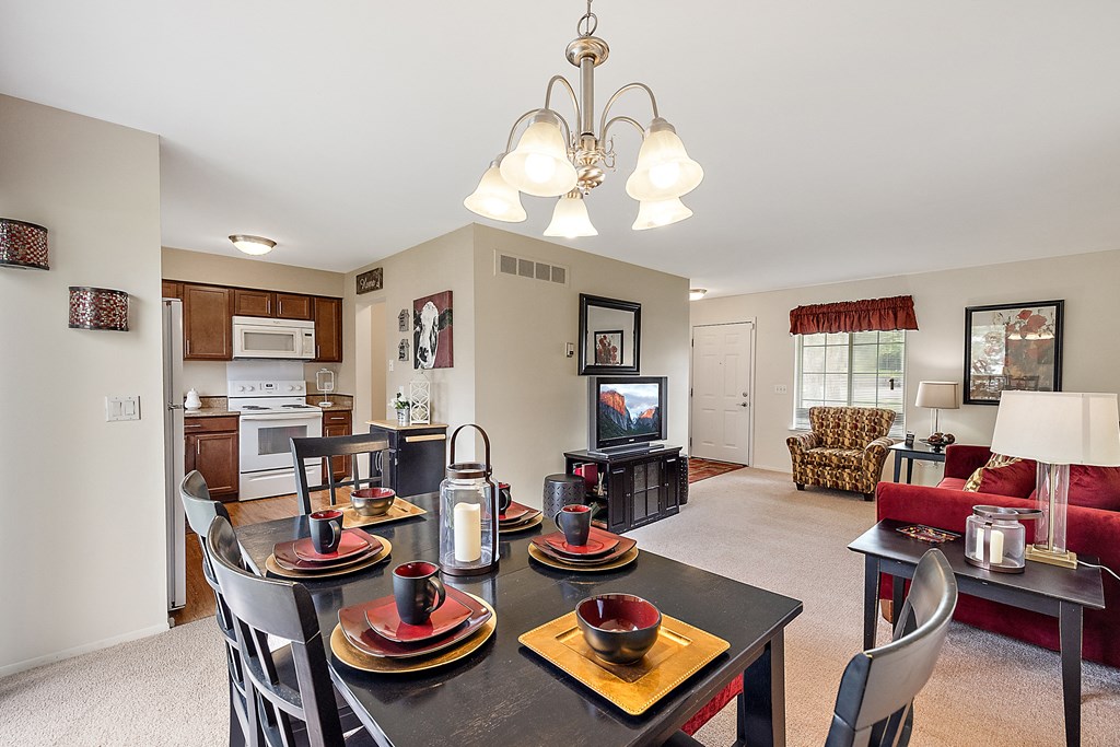 a dining area with a table and chairs and a living room in the background  at Northridge, Rochester Hills, Michigan