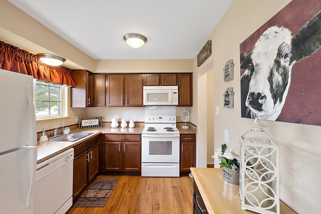 a kitchen with white appliances and wooden cabinets  at Northridge, Rochester Hills, MI, 48307