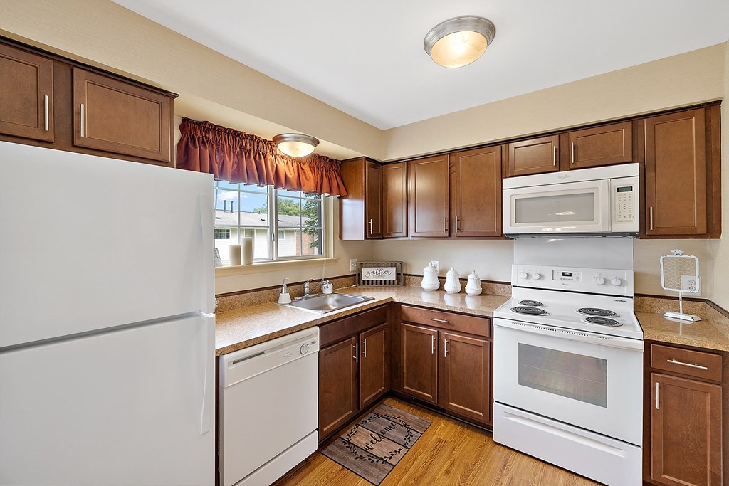 a kitchen with white appliances and brown cabinets at Northridge, Michigan, 48307
