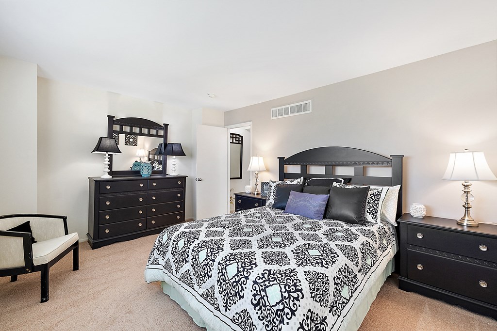 a bedroom with a large bed and two dressers  at Northridge, Michigan, 48307