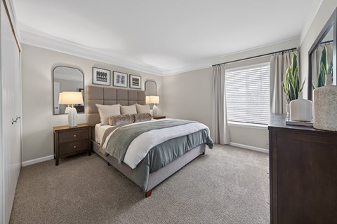 A bedroom with a large bed and a mirror on the wall.