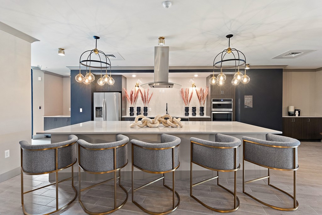 a large kitchen with a large island and a row of stools  at The Griffin Royal Oak, Royal Oak, 48067