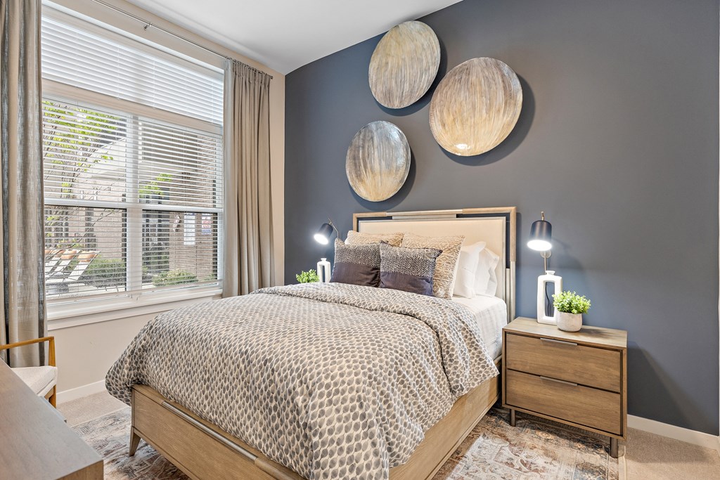 a bedroom with gray walls and a bed with a wooden headboard a bedroom with gray walls and a bed with a wooden headboard at The Griffin Royal Oak, Royal Oak, 48067