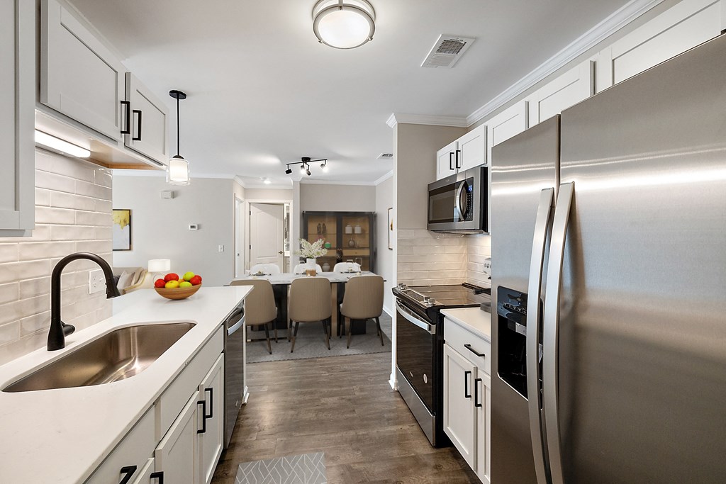 a kitchen and dining room with stainless steel appliances and a sink a kitchen and dining room with stainless steel appliances and a sink at Cidermill Village, MI