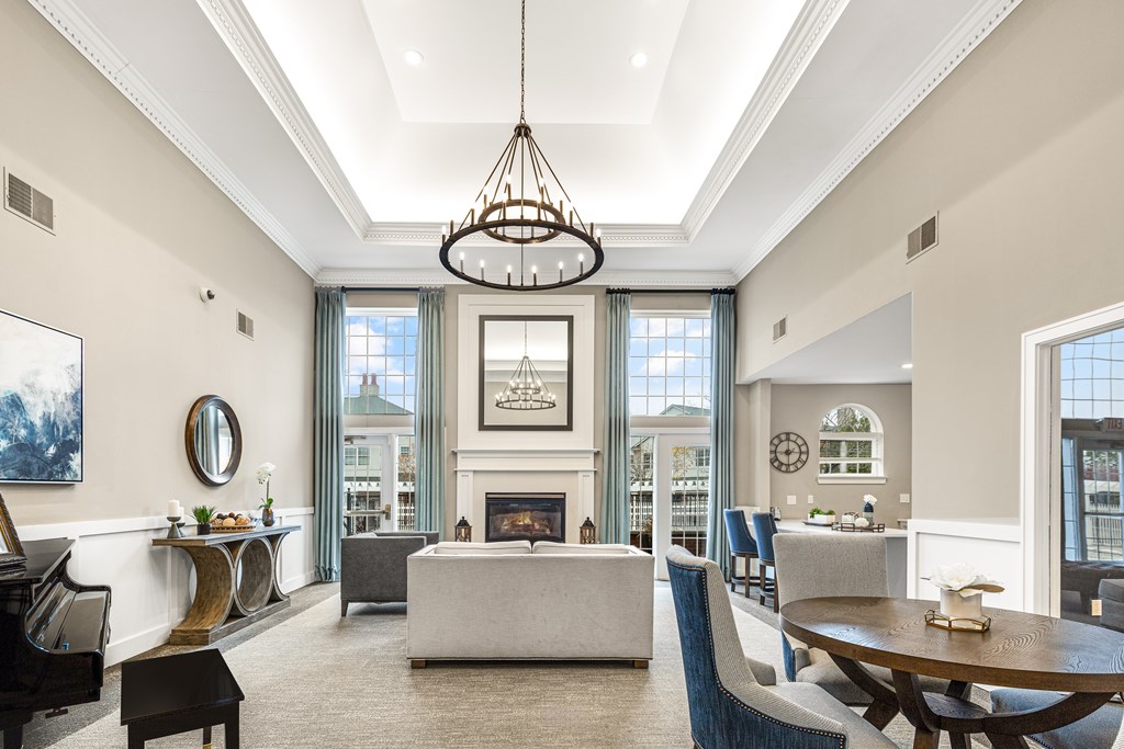 A large, well-lit living room with a fireplace and a dining table.