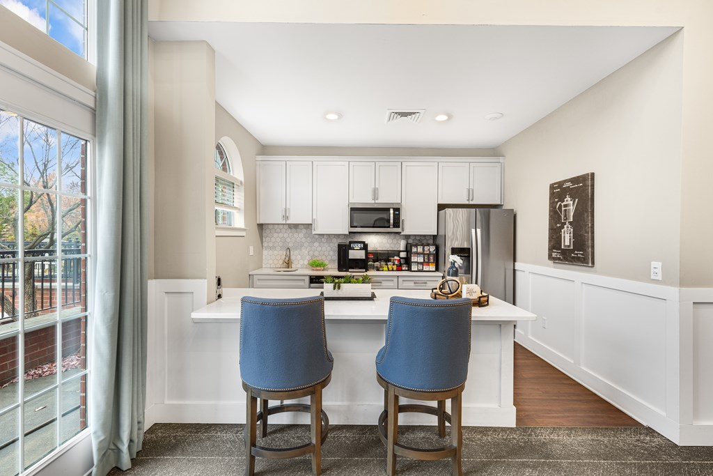 A kitchen with a white countertop and blue chairs.