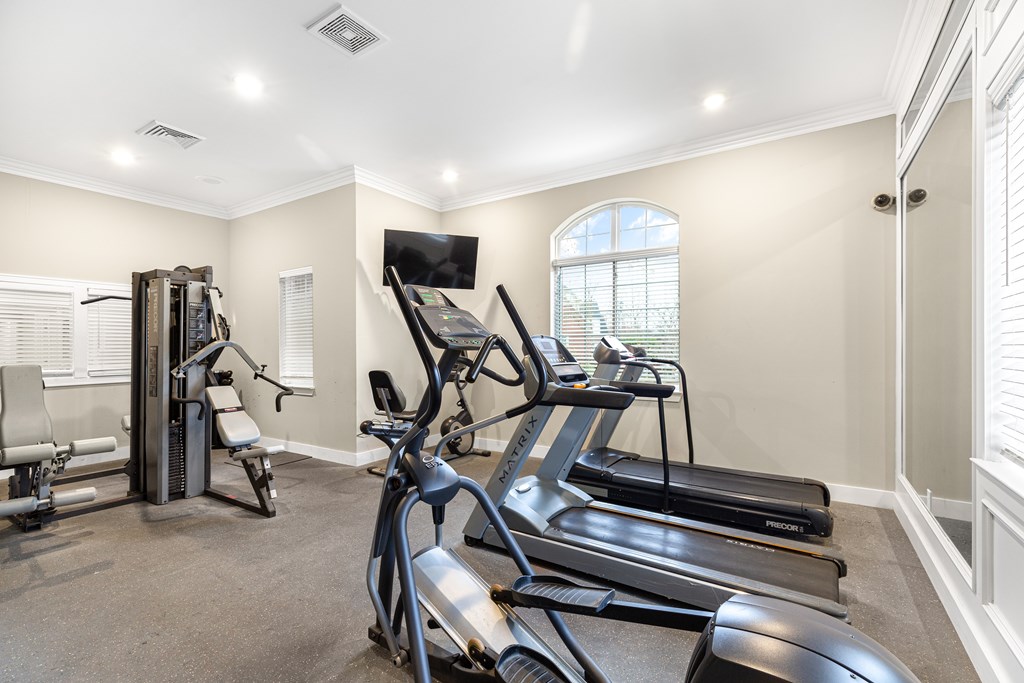 A home gym with treadmills and elliptical machines.