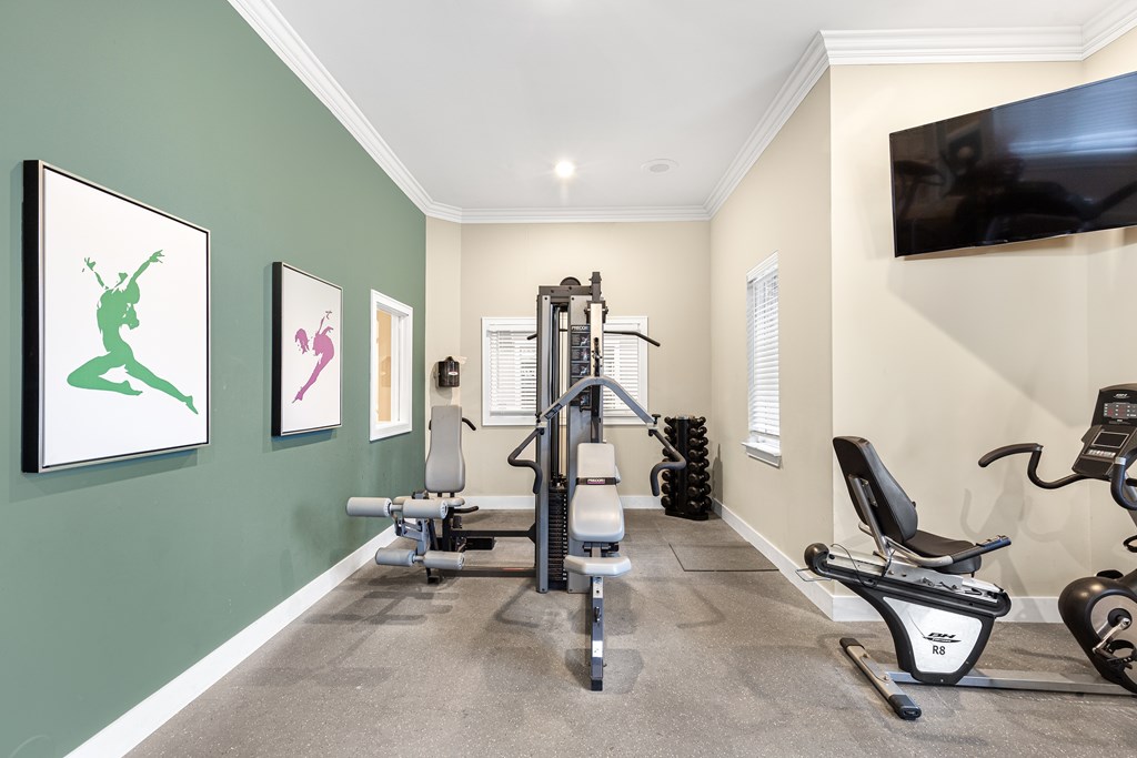 A home gym with a green wall and exercise equipment.