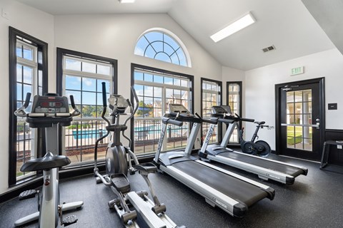 A gym with treadmills, elliptical machines, and stationary bikes.