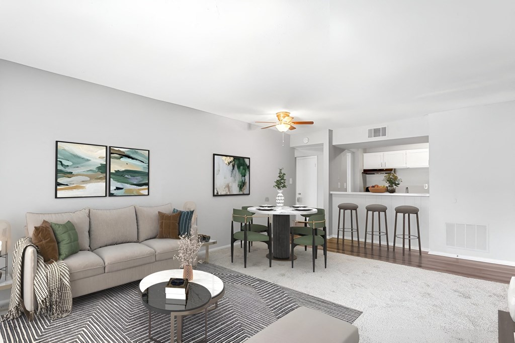 a living room with a couch a table and a chair and a kitchen in the background  at Lakes Edge Apartments, Greensboro, North Carolina