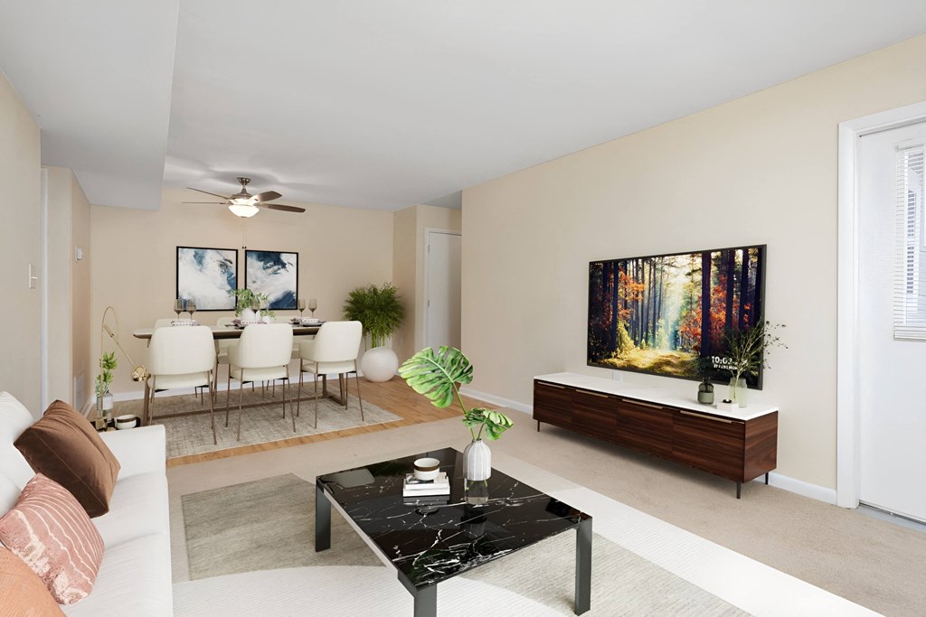 a living room with a couch and a table and a television at West Pointe Apartments in Burlington, NC