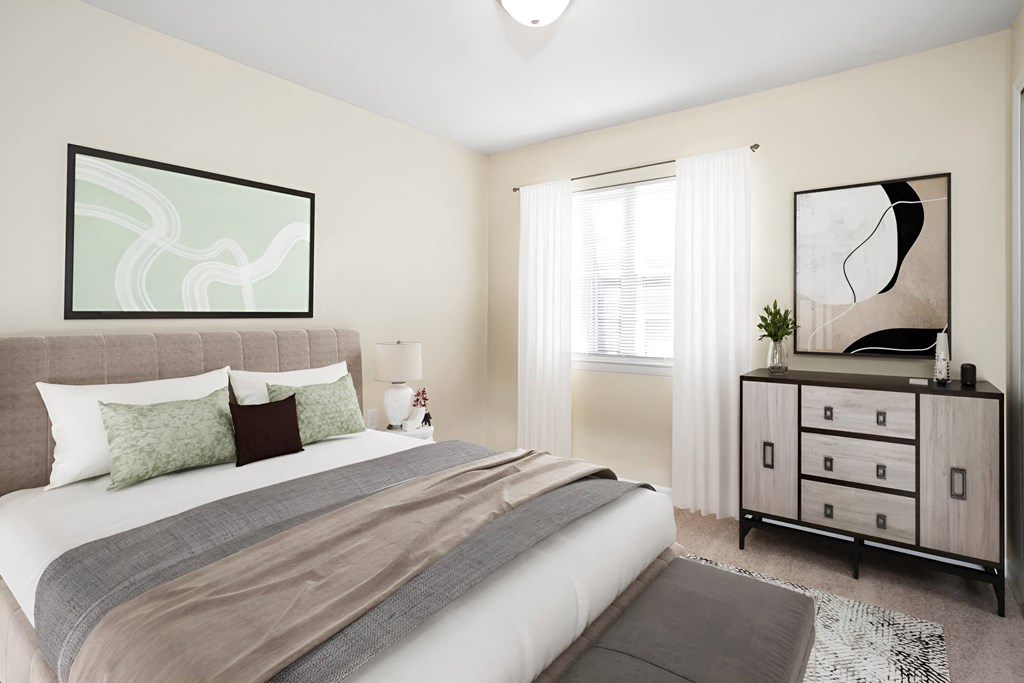 a bedroom with a bed and a dresser at West Pointe Apartments in Burlington, NC