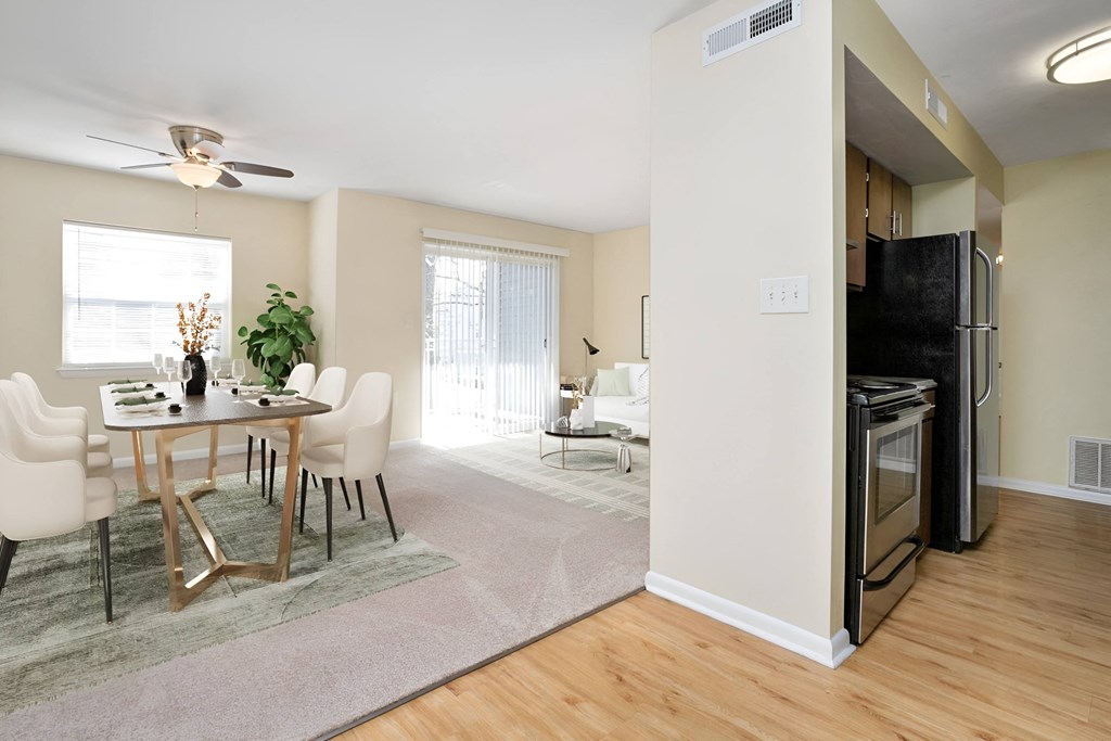 an open living room and dining room with a table and chairs at West Pointe Apartments in Burlington, NC