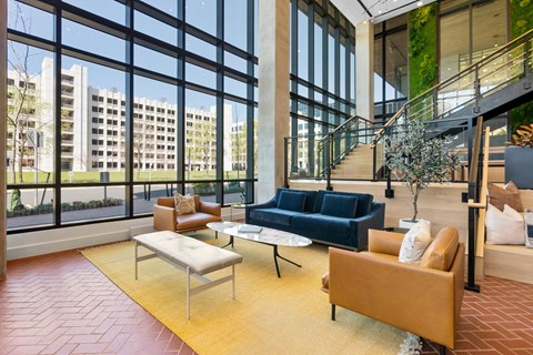 a living room with couches and chairs in front of large windows