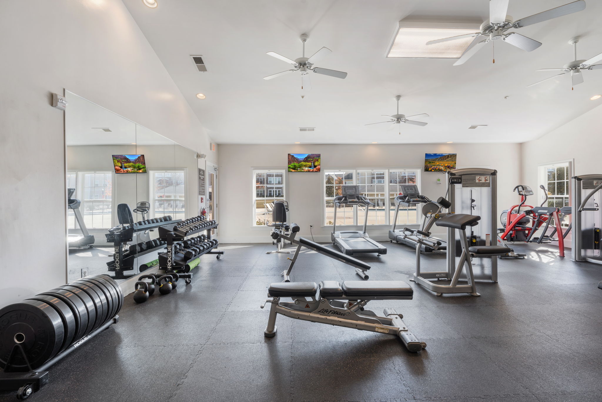 A spacious gym with a variety of equipment including weights and cardio machines.