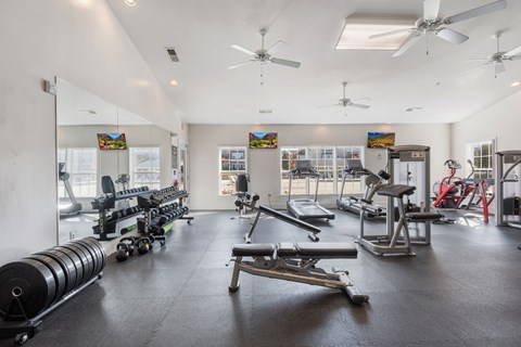 A spacious gym with a variety of equipment including weights and cardio machines.