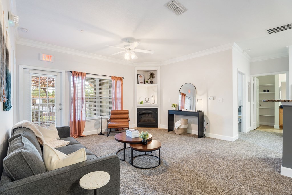 A living room with a grey couch, a coffee table, and a fireplace.