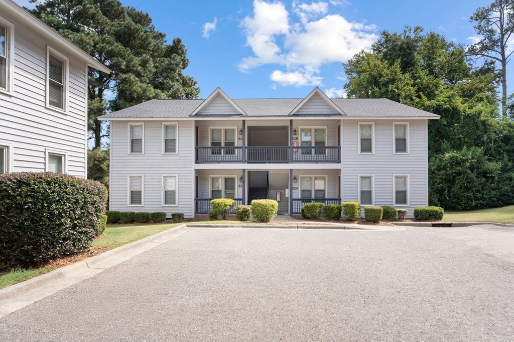 A two-story house with a balcony on the second floor.