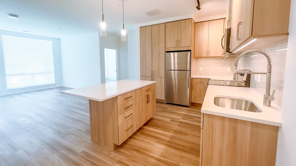 a kitchen with wooden cabinets and a stainless steel refrigerator