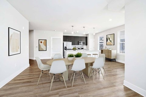 A modern dining room with a white table and chairs.
