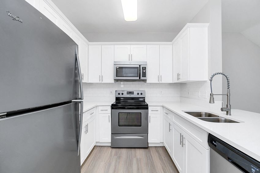 a kitchen with white cabinets and stainless steel appliances - Photo Gallery