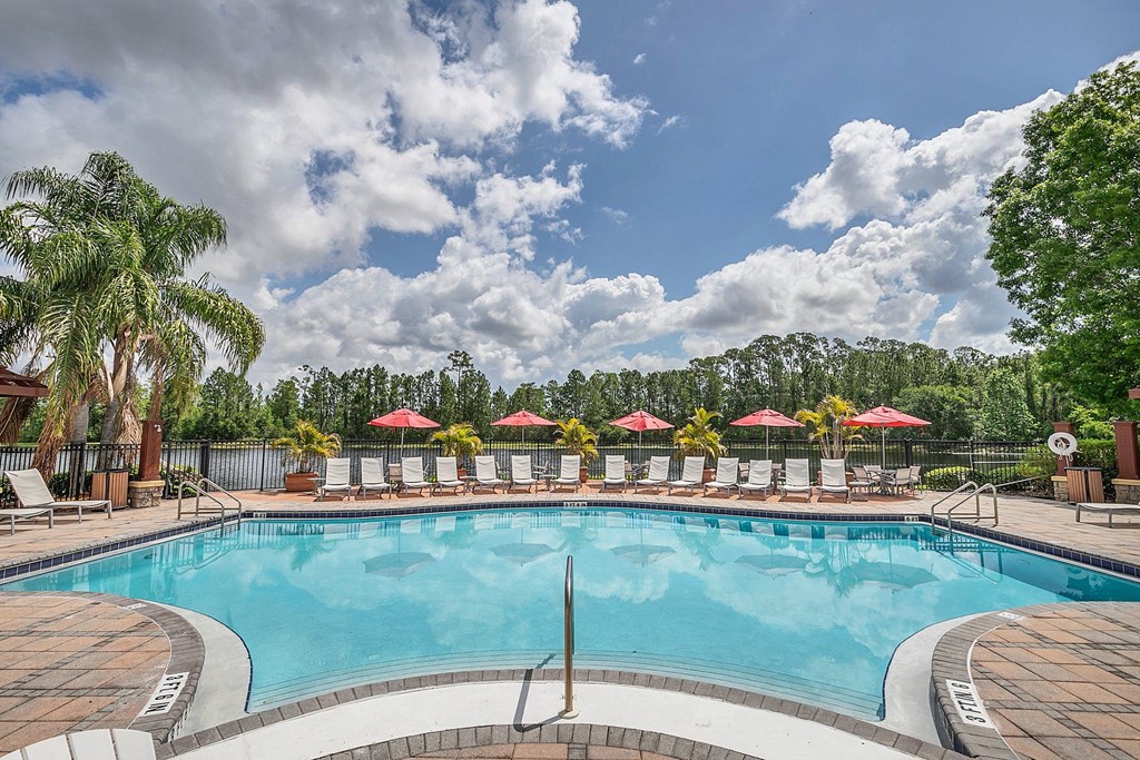 a resort style pool with lounge chairs and umbrellas at Northlake Park, Orlando, 32827