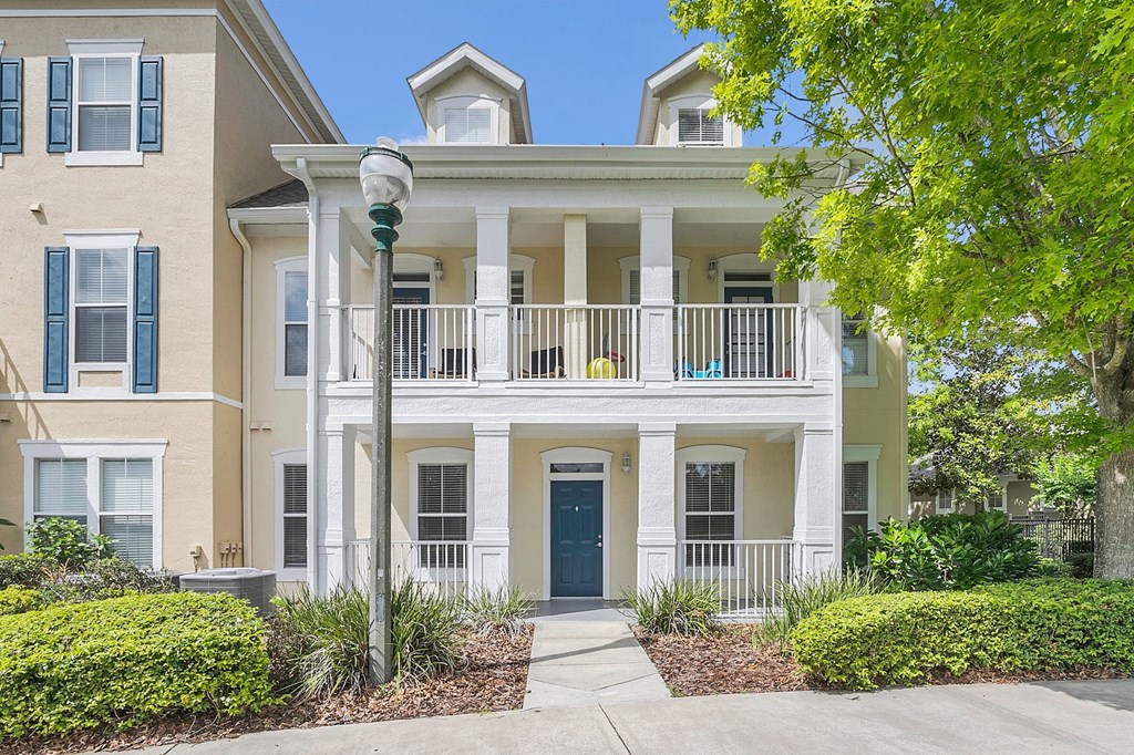 an apartment building with a blue door and a balcony at Northlake Park, Orlando