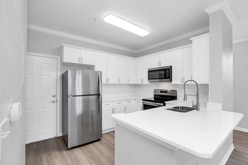 a kitchen with white cabinets and stainless steel appliances - Photo Gallery