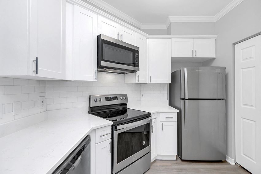 a kitchen with white cabinets and stainless steel appliances - Photo Gallery