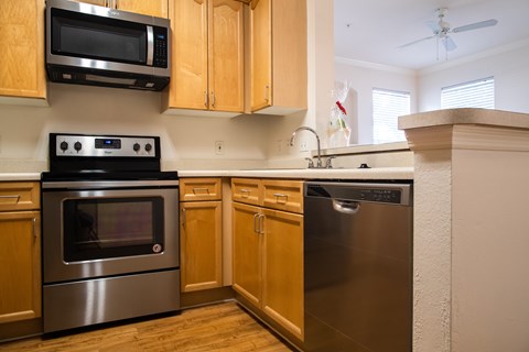 A kitchen with wooden cabinets and stainless steel appliances.