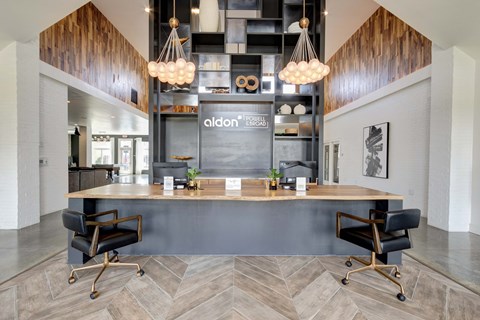 A modern office space with a reception desk and two chairs.