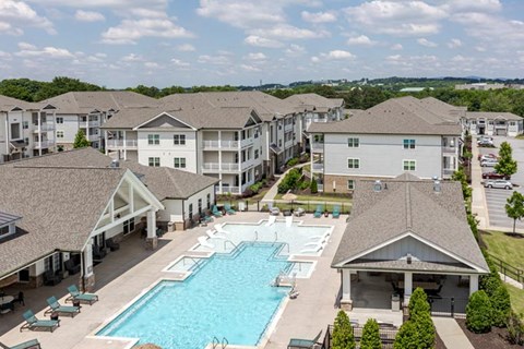 A large swimming pool is surrounded by apartment buildings.