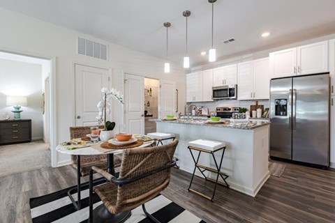 A kitchen with a table and chairs in the middle of the room.