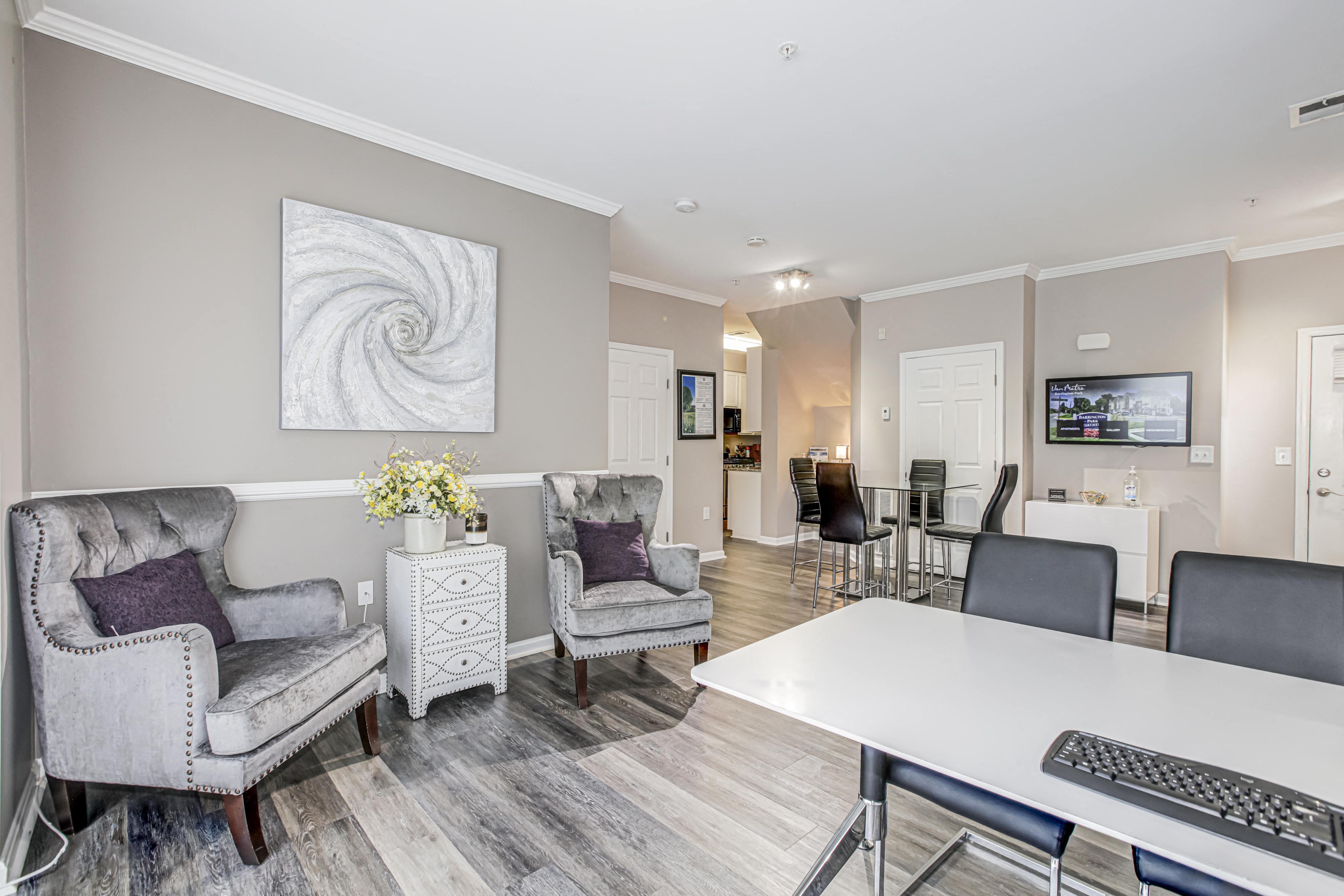 a living room with chairs and a table and a computer