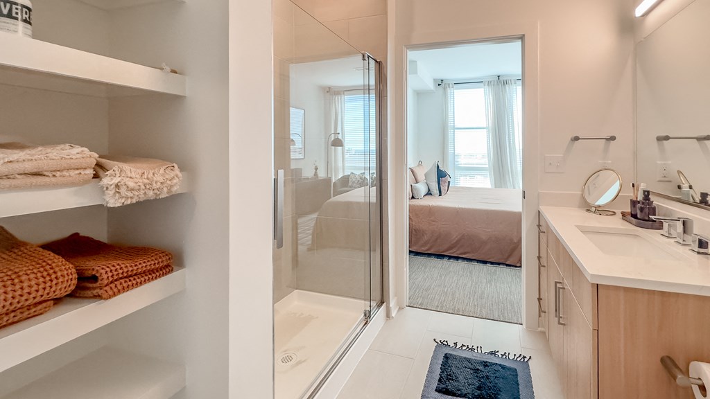 a bathroom with a shower and a sink and a bed