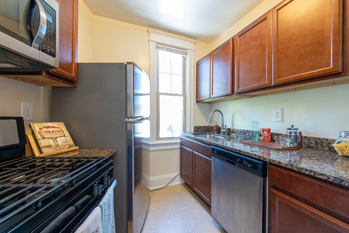 A kitchen with a black stove top oven and a black dishwasher.