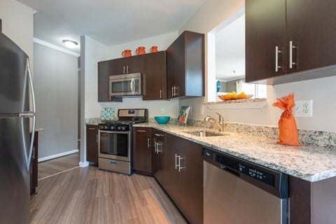 A kitchen with dark brown cabinets and stainless steel appliances.