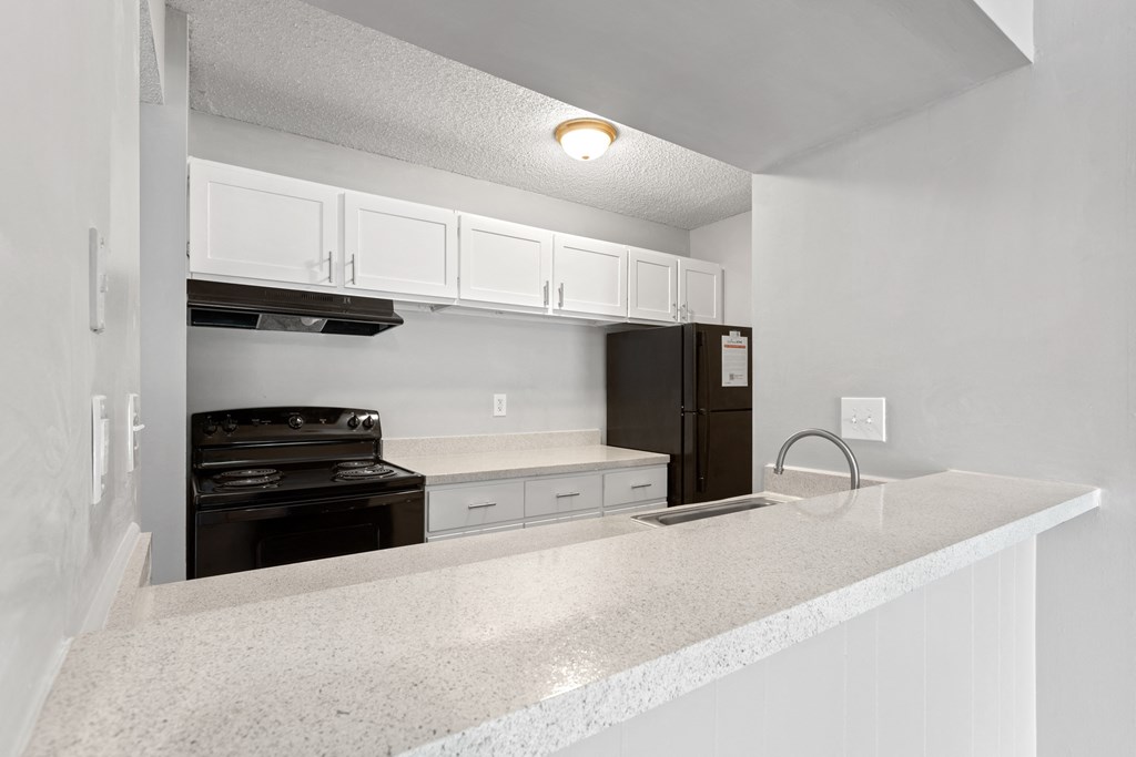 a kitchen with white cabinets and appliances  at Lakes Edge Apartments, North Carolina