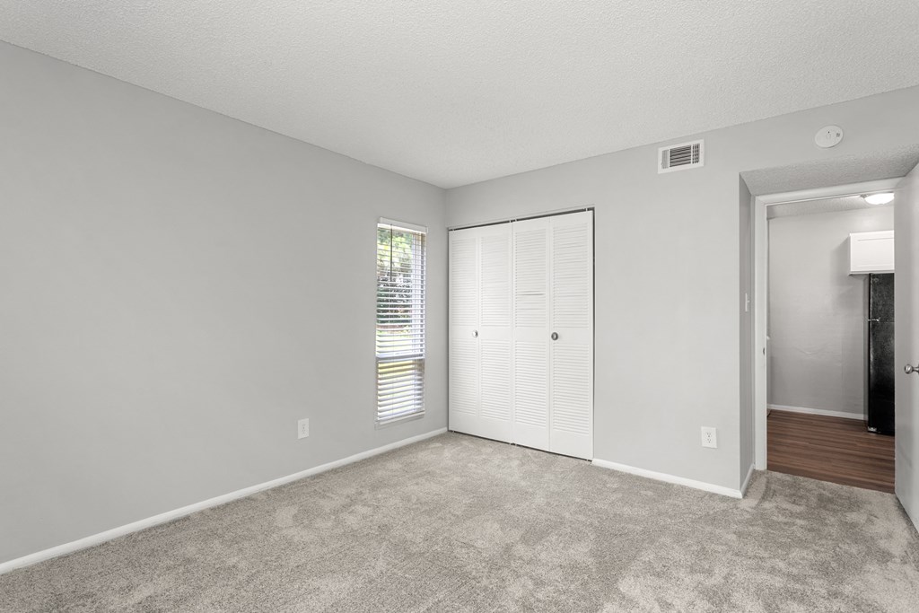 an empty bedroom with a closet and a door to the bathroom  at Lakes Edge Apartments, Greensboro, NC