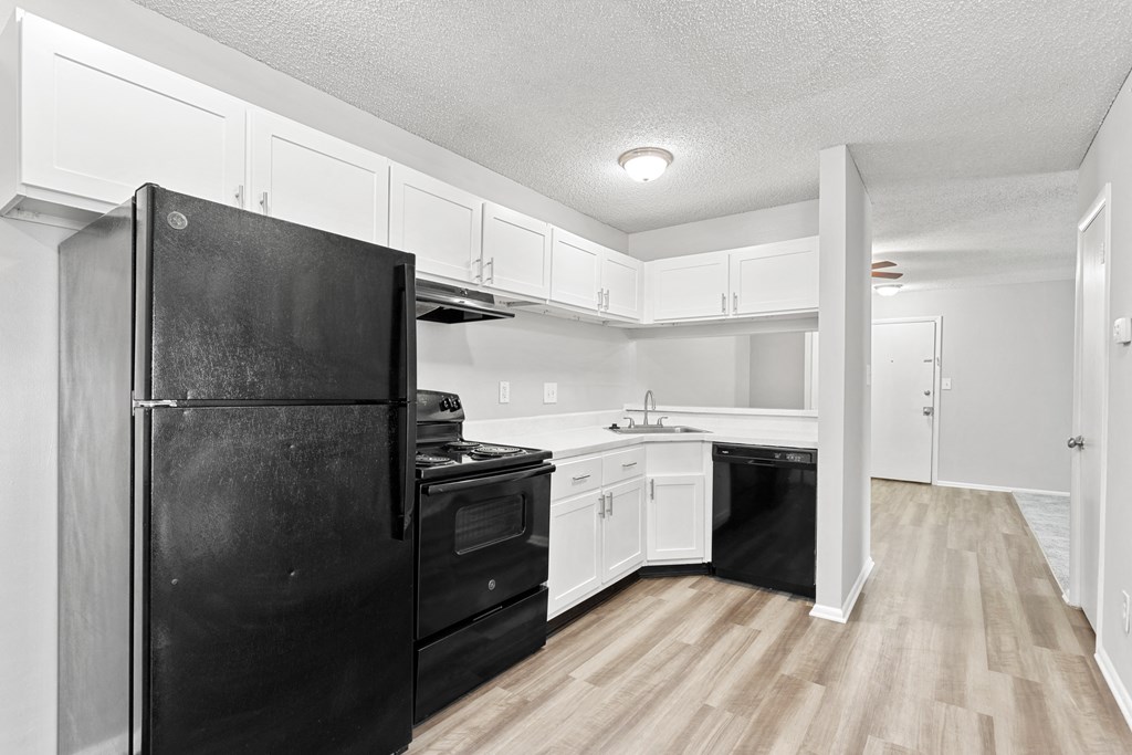 a kitchen with white cabinets and black appliances  at Lakes Edge Apartments, Greensboro, NC, 27409