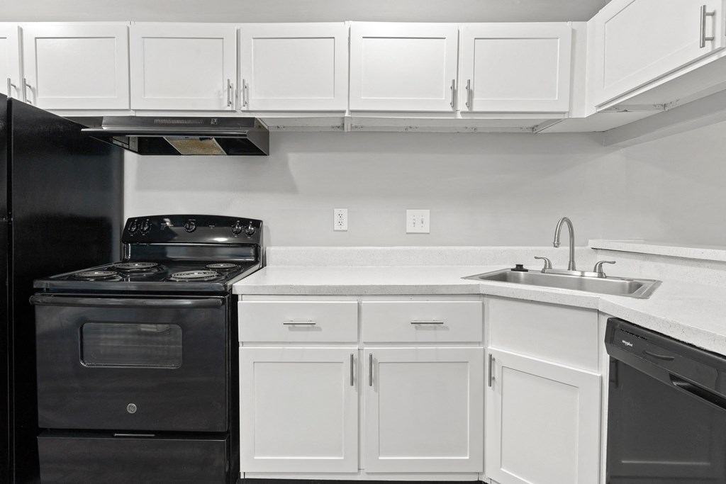 a kitchen with white cabinets and black appliances  at Lakes Edge Apartments, Greensboro, NC, 27409