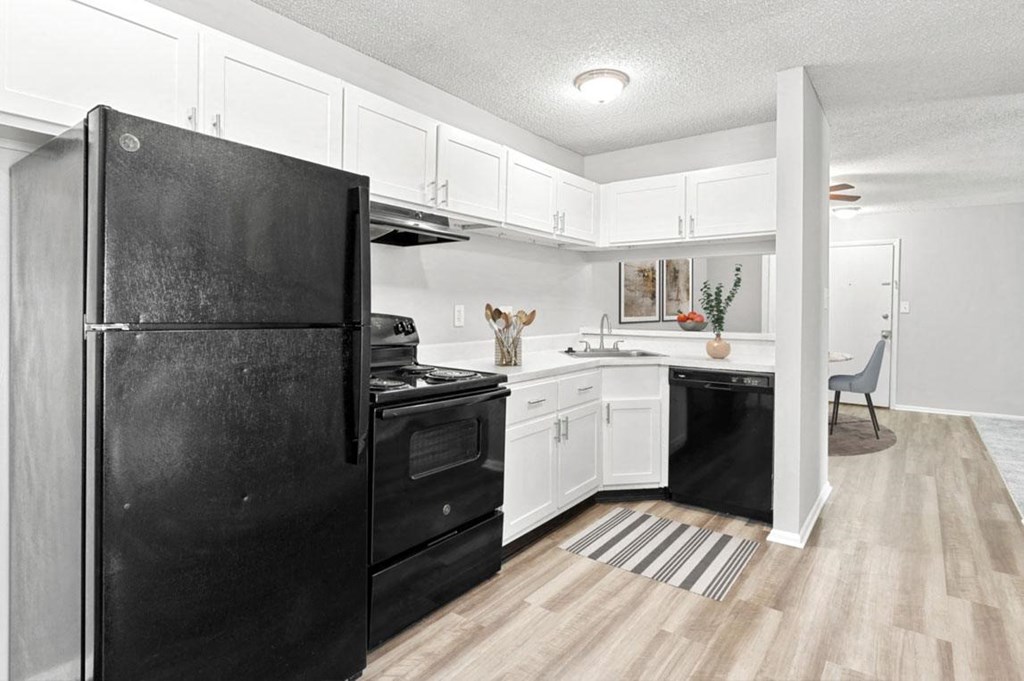 Open Kitchen with Black Appliances and White Cabinets at Lakes Edge Apartments, Greensboro, North Carolina