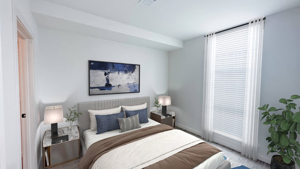 A bedroom with a large bed, two lamps, and a painting on the wall.at Makers Rise, Herndon, VA 20171